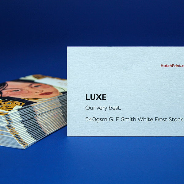 Animation representing production of Luxe line of business cards. Blue paper are pressed in the middle of two white sheets, forming a coloured seam.