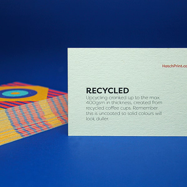 2 white business cards out-lined in blue. The left card contains a square in the upper left and copy 'Name here, Job title here' on the right. The other card contains a large upward facing arrow within a circle. It represents the first step when ordering with Hatch: select your product.